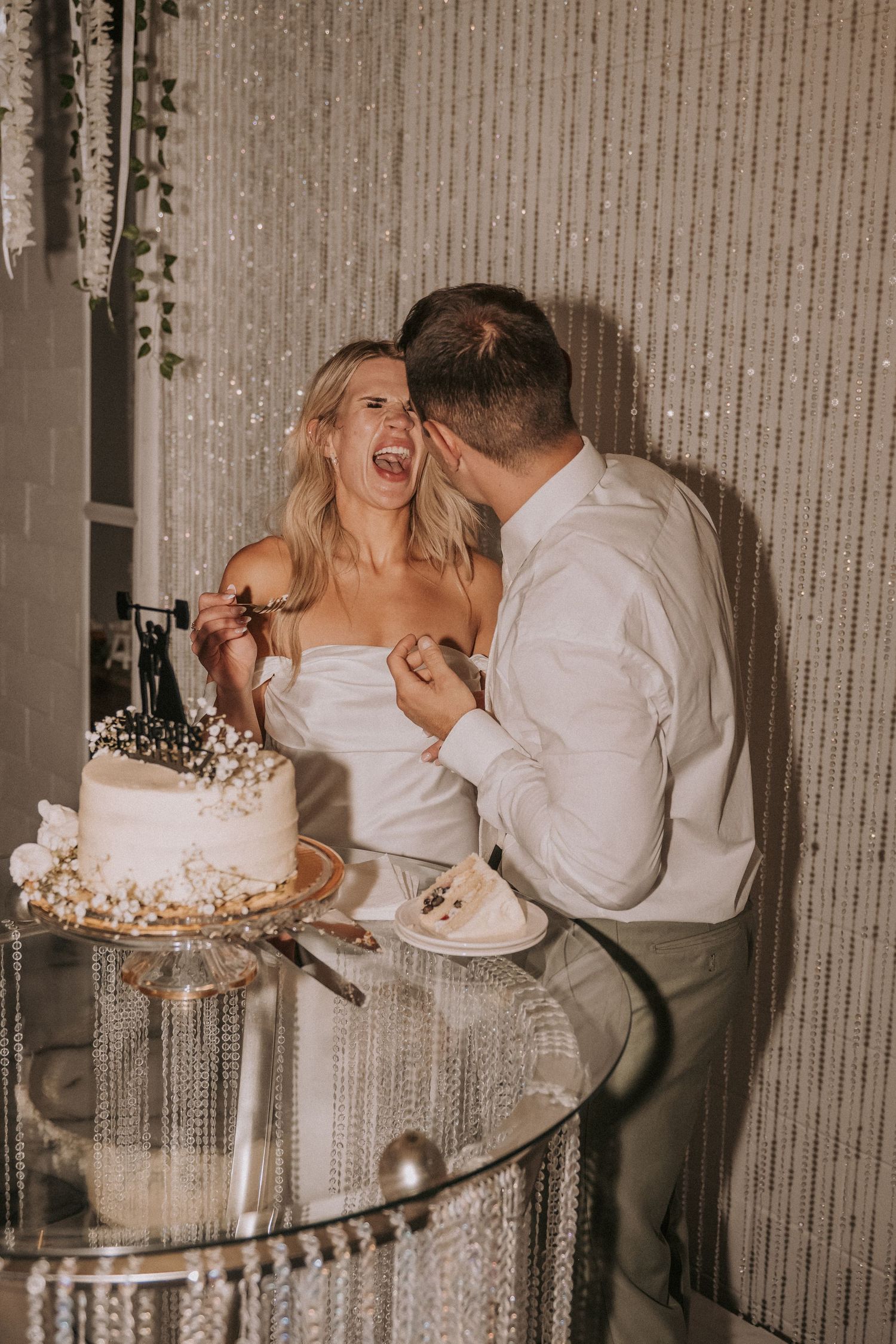 A playful moment at a wedding reception as two people share cake. romantic wedding photographers New Mexico. Affordable wedding photos abq