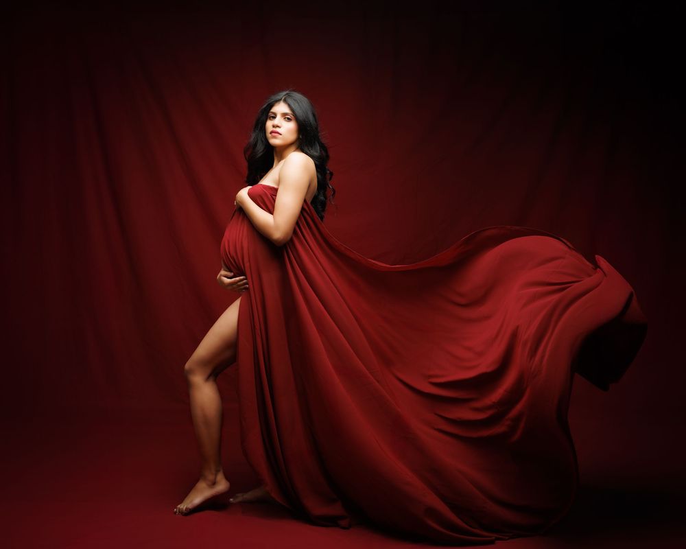 A flowing red dress fabric creates a repeating pattern against a dramatic dark background in an artistic series.
