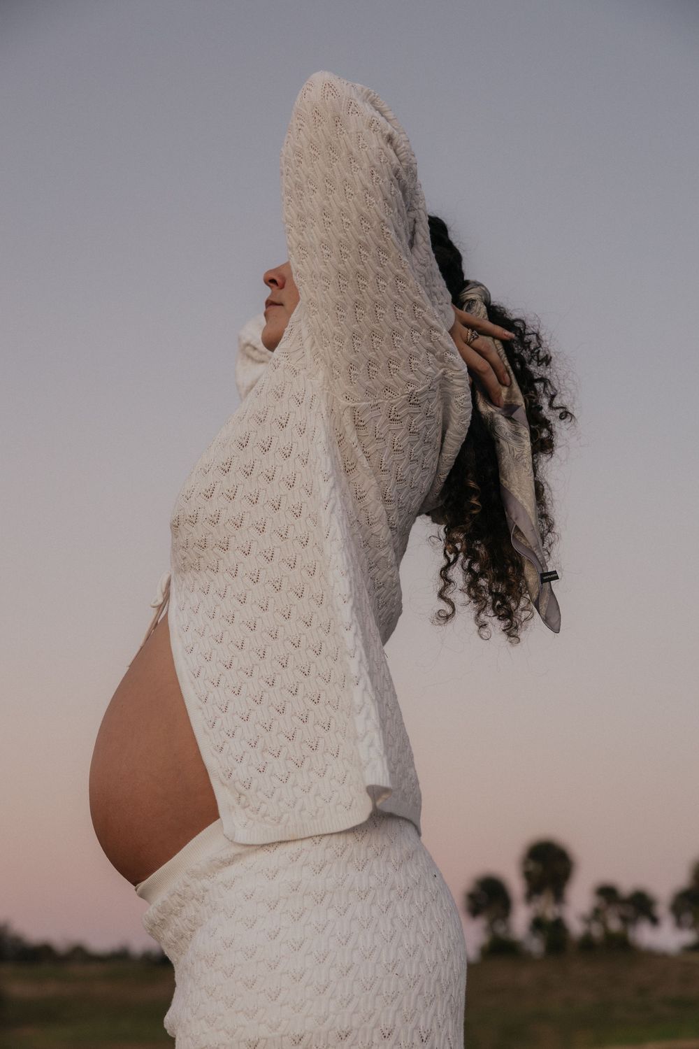 A series of profile shots showing a person wearing a white knitted sweater in an outdoor setting at sunset.