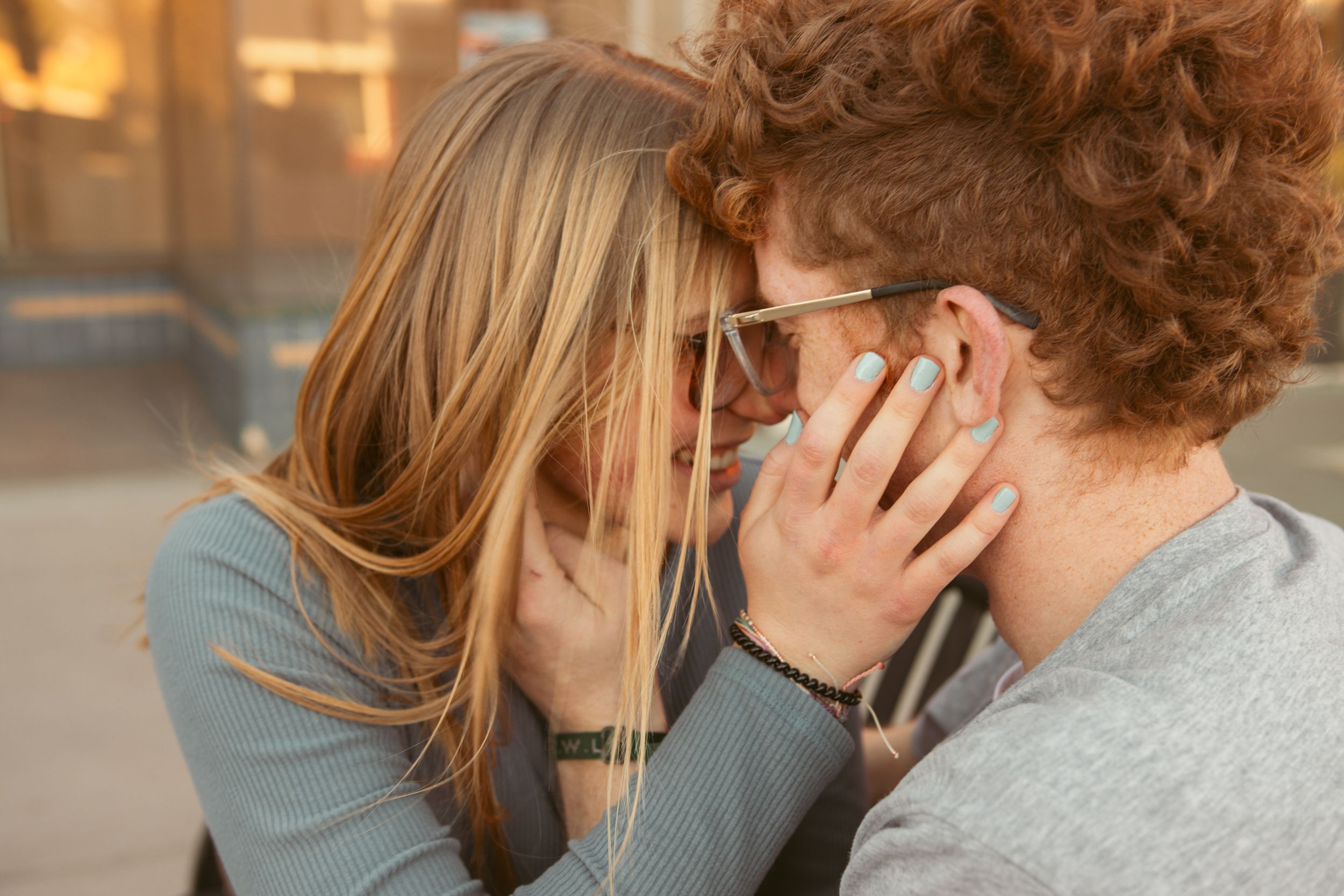 A series of candid photos depicting tender romantic moments between a couple in warm lighting.
