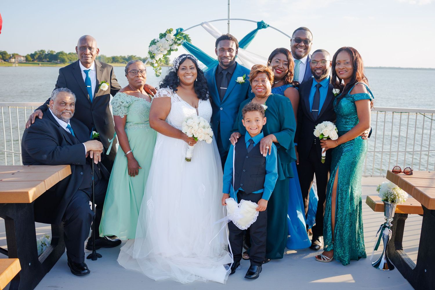 A festive group of formally dressed wedding guests posing together for a fun photo at a celebration.