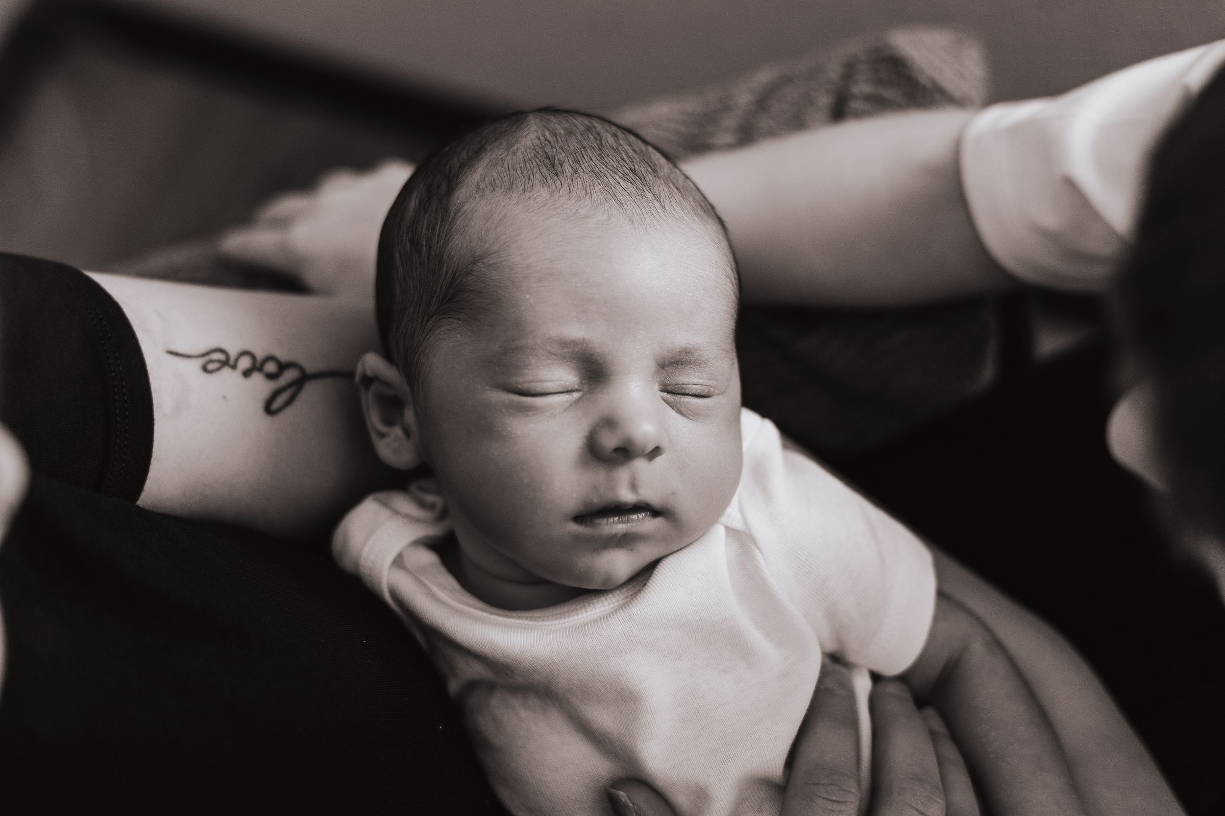 A peaceful sleeping newborn baby in black and white photography.