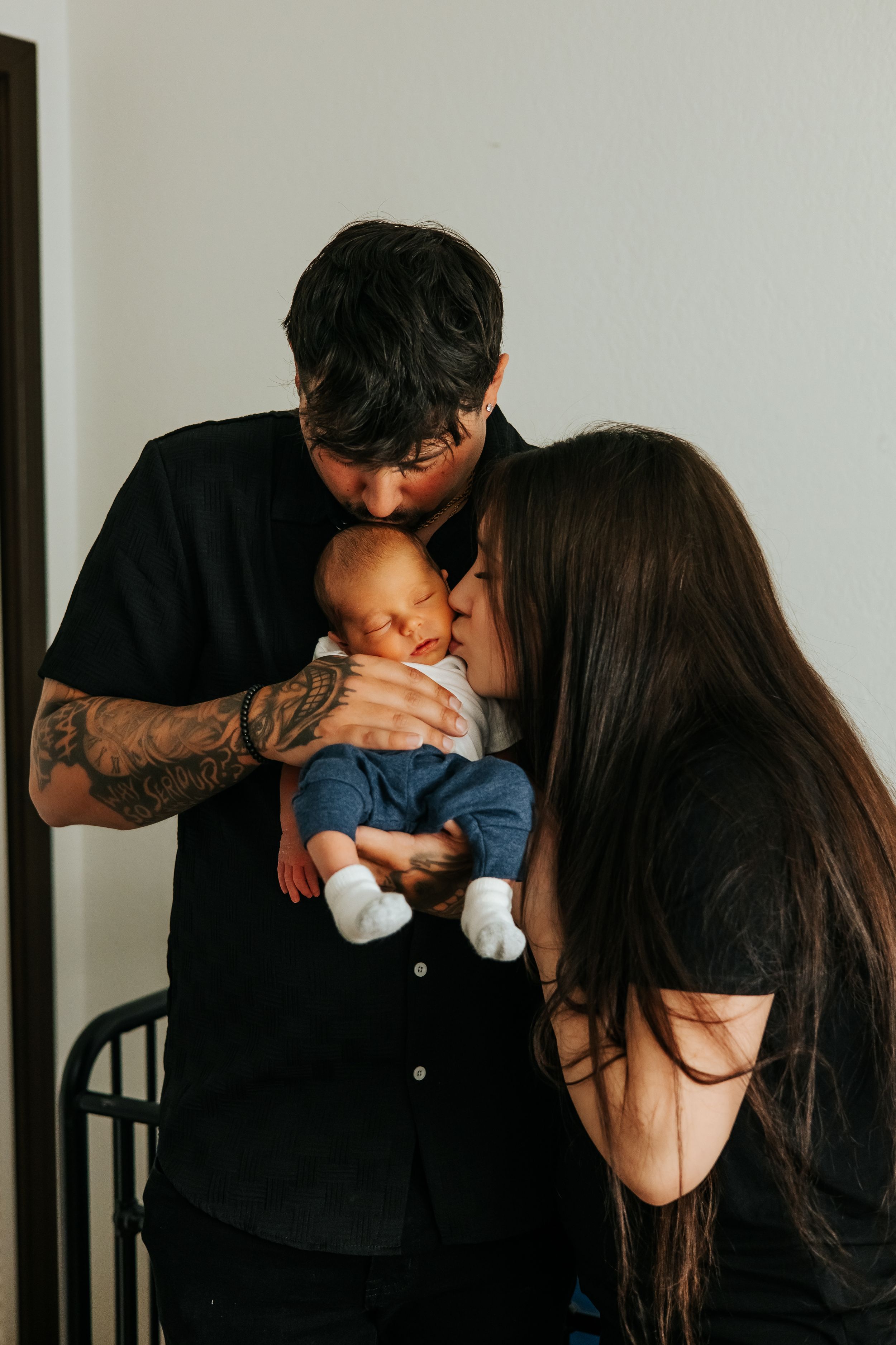 Parents sharing a tender moment with their sleeping baby.