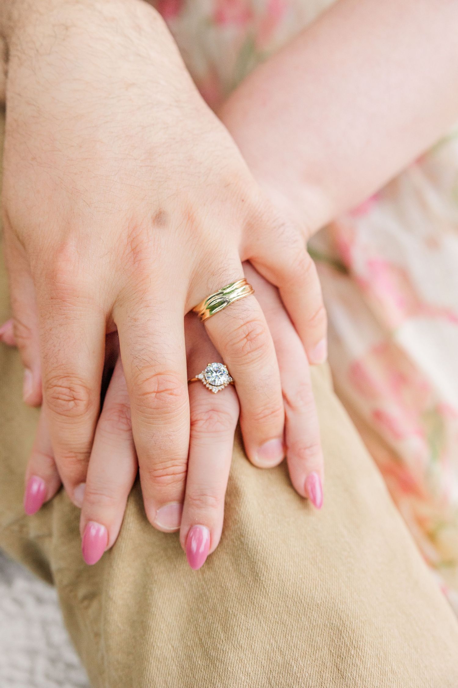 Multiple close-up shots of hands wearing engagement rings with pink nail polish against a beige textured fabric background.