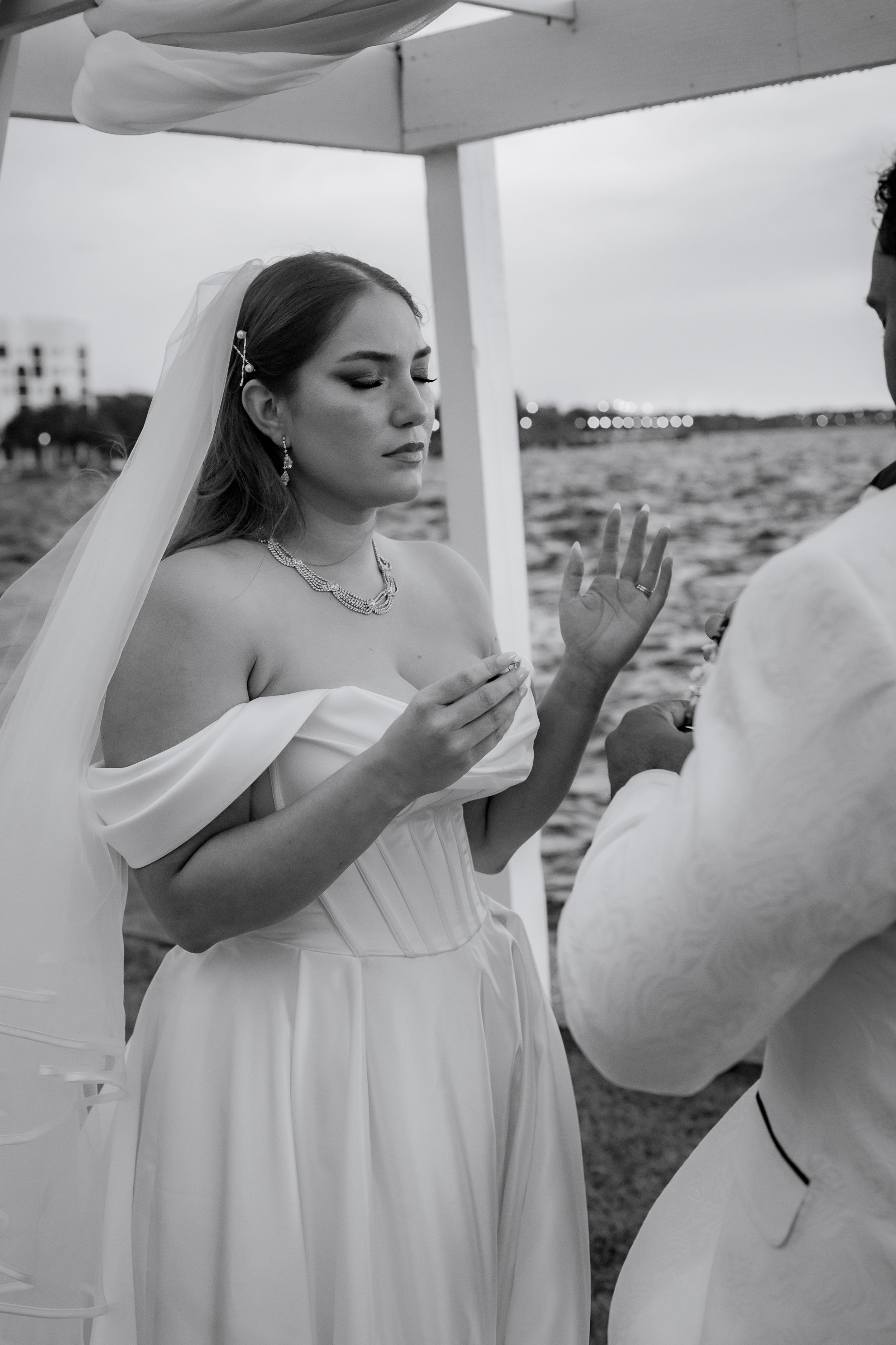 A series of black and white photos showing a bride in a flowing white dress and veil posing outdoors.