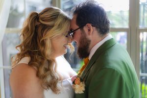 Couple shares intimate moment during first dance in naturally lit indoor venue.