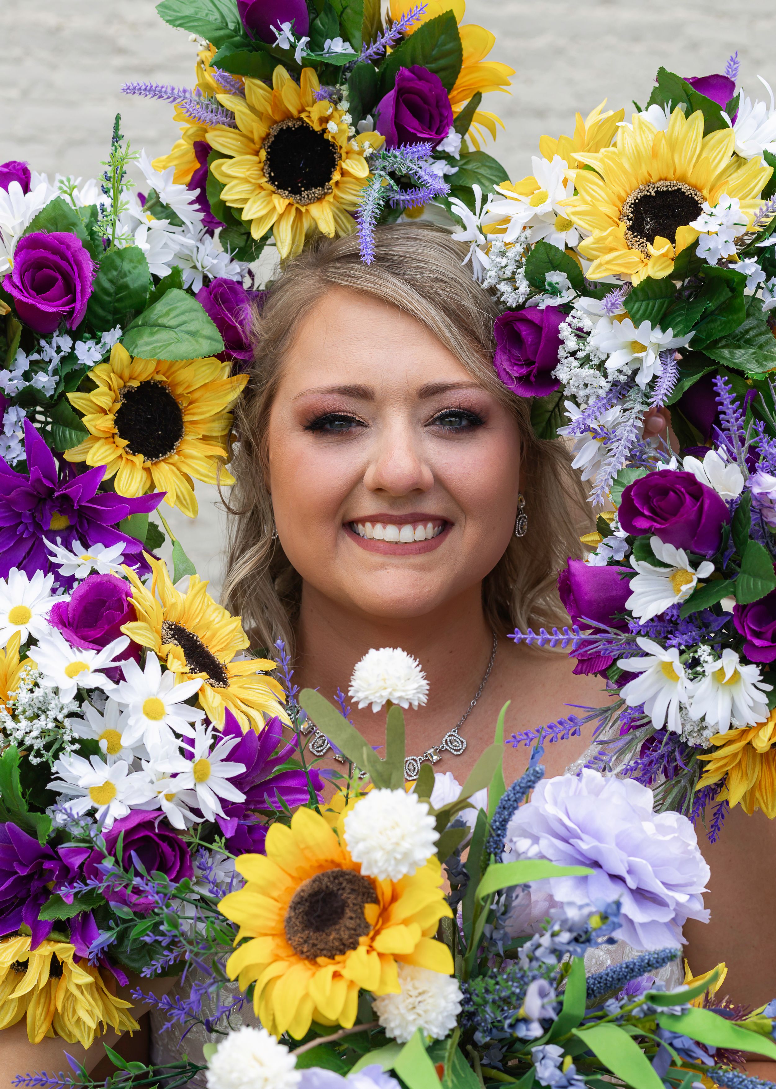 Colorful bridal flower crown featuring sunflowers, daisies, and purple blooms.