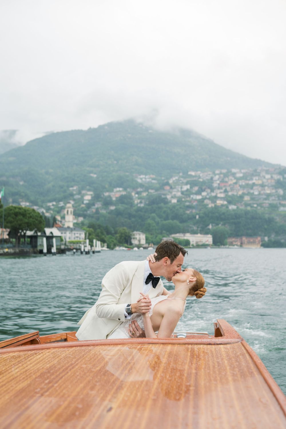 A romantic boat ride on a wooden vessel with mountains and lake views.