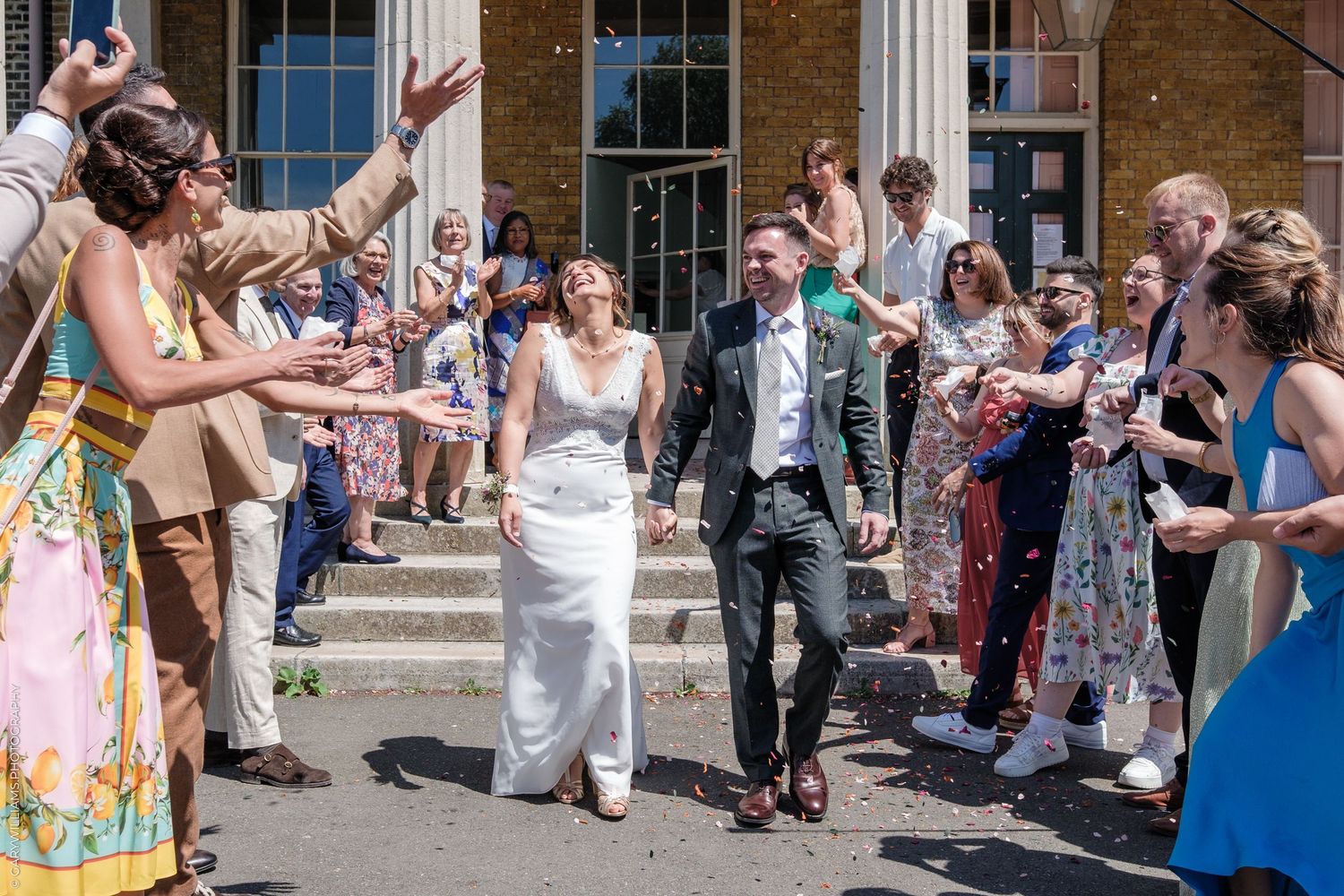 Wedding guests line up outdoors holding bubble wands to create a festive celebration atmosphere during the exit.