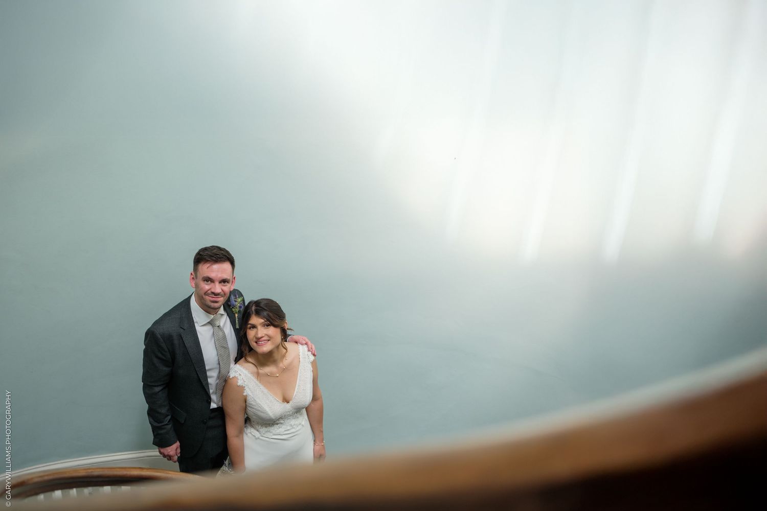 Two people share an intimate moment while dancing together at their wedding reception.