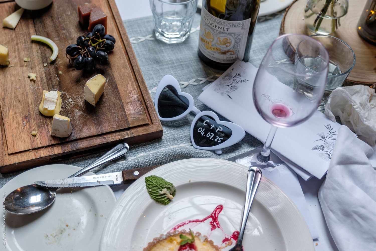 Romantic table setting with wine glasses, cheese board, and heart-shaped plates for an intimate dinner.