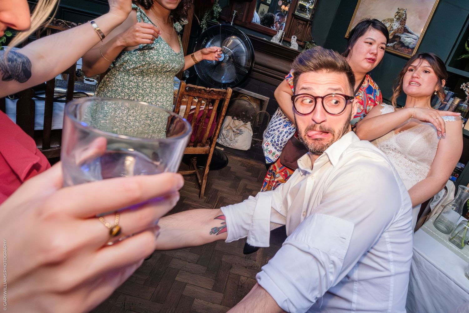People celebrating with drinks at a lively party in a bar or restaurant setting with dynamic expressions and movement.