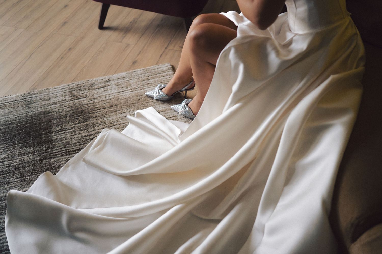 Wedding dress seamstress makes detailed adjustments to white bridal gown during final fitting.