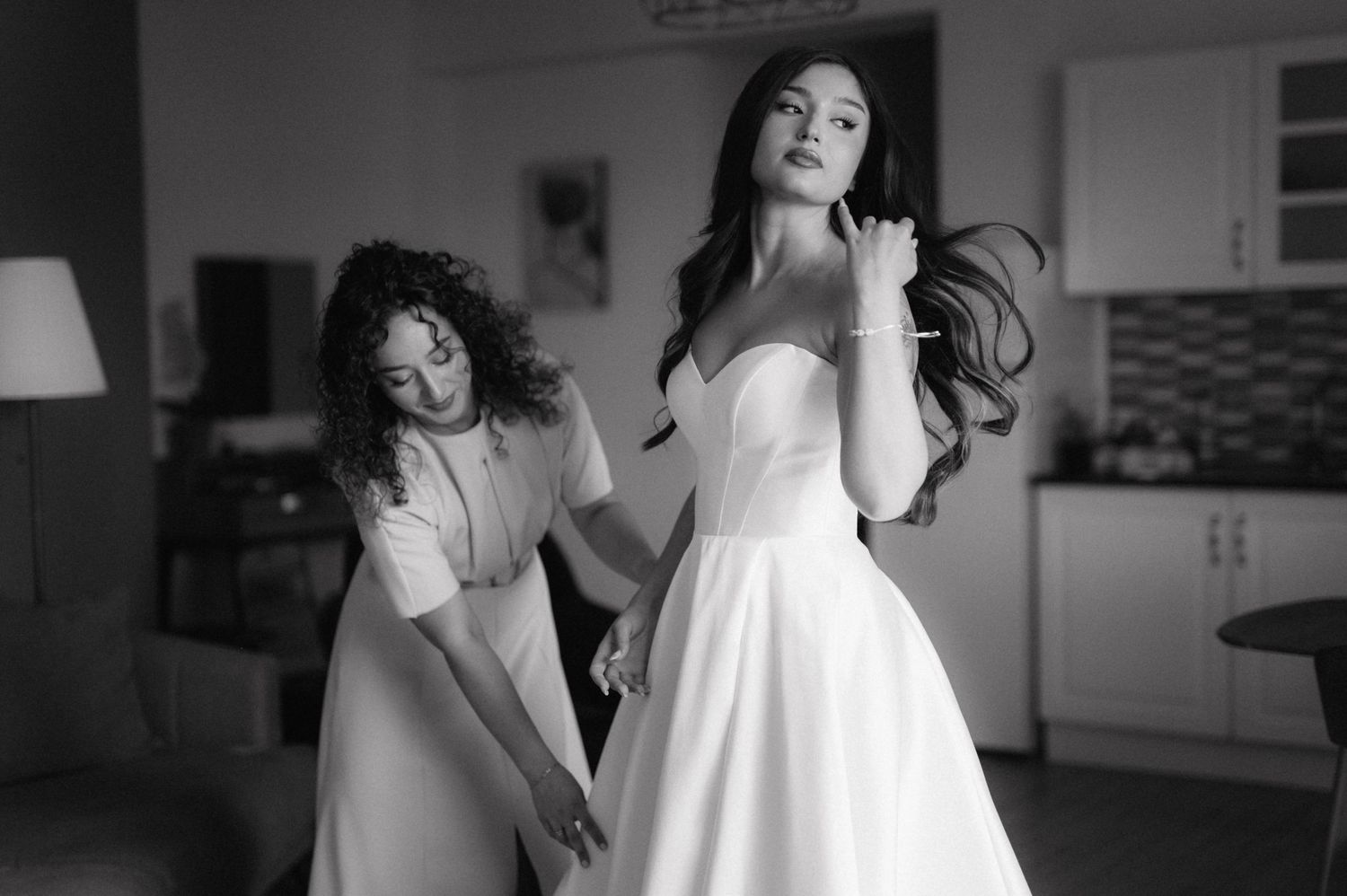 Black and white fashion portrait series showing poses in white dress against dark interior.