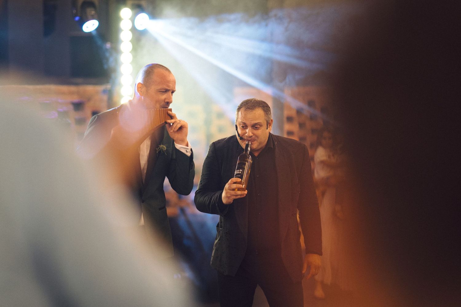 People gathered under dramatic stage lighting at what appears to be a social event or party.