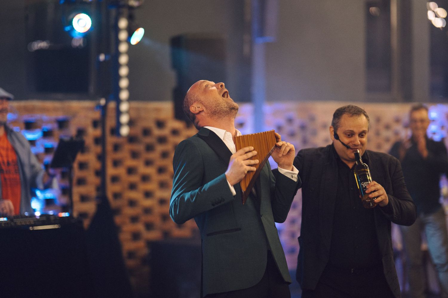 Two performers singing passionately on stage with dramatic lighting.