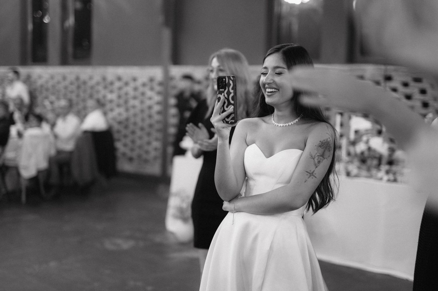 Wedding celebration in a reception hall with joyful moments being captured on camera.