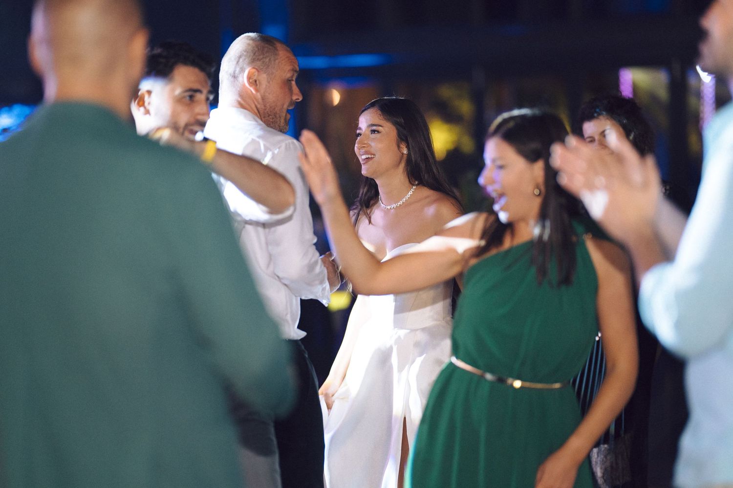 Wedding guests dancing and celebrating on the reception dance floor.