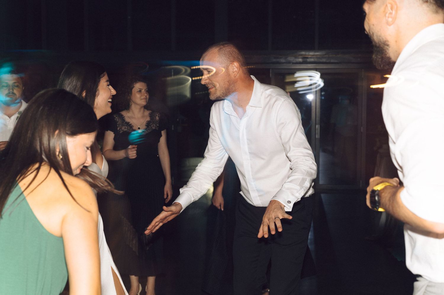 Guests dancing and having fun at a lively wedding reception party.