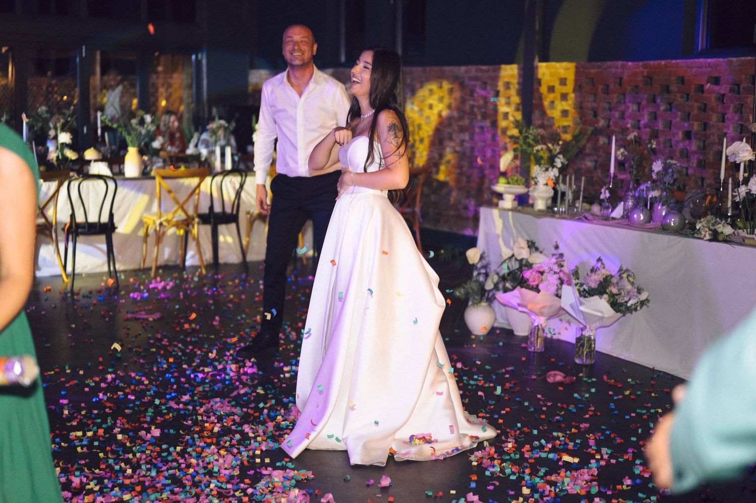 Wedding reception dance floor filled with confetti and colorful party lights.