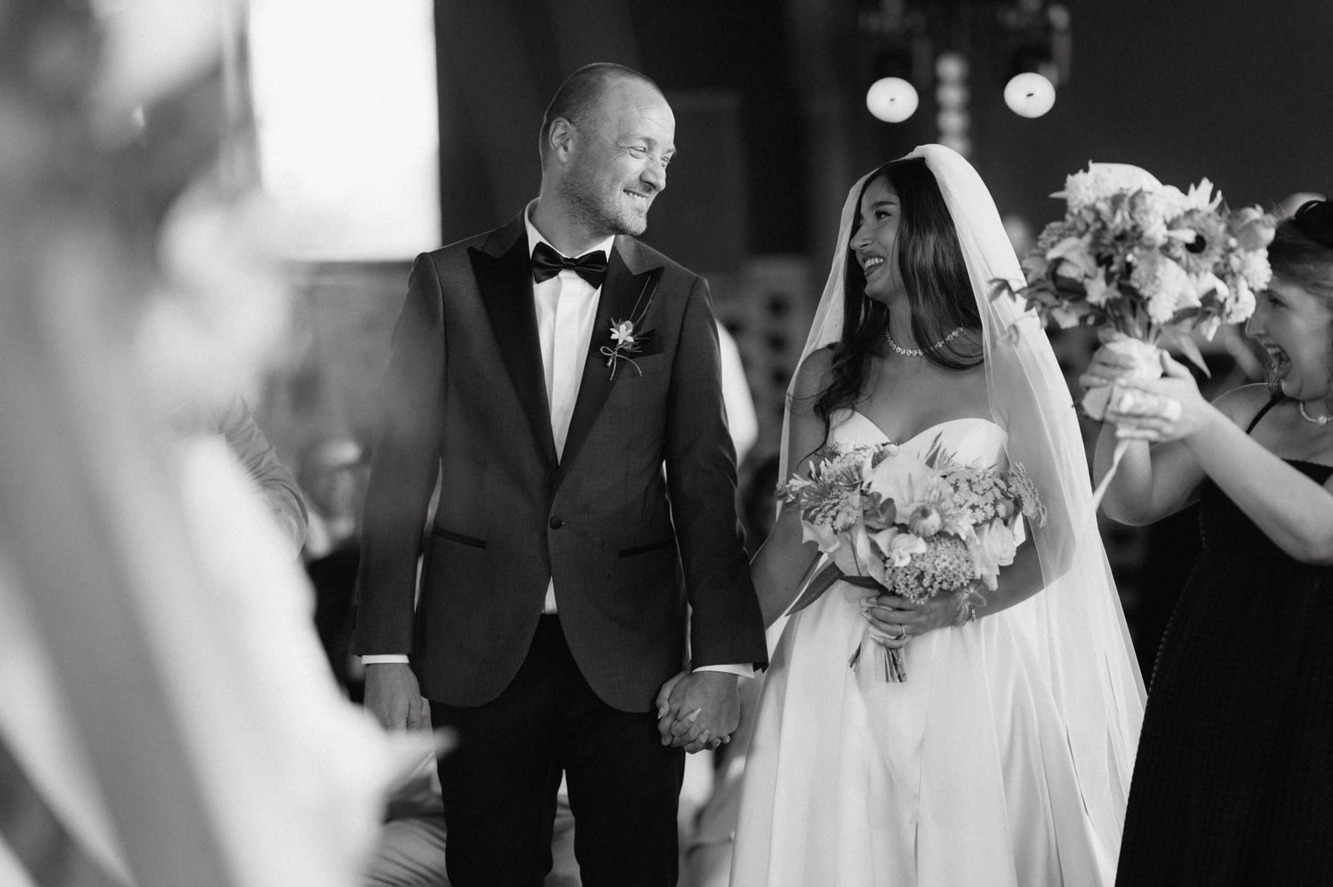A collage of black and white wedding photos showing romantic moments and celebration details from a couple's special day.