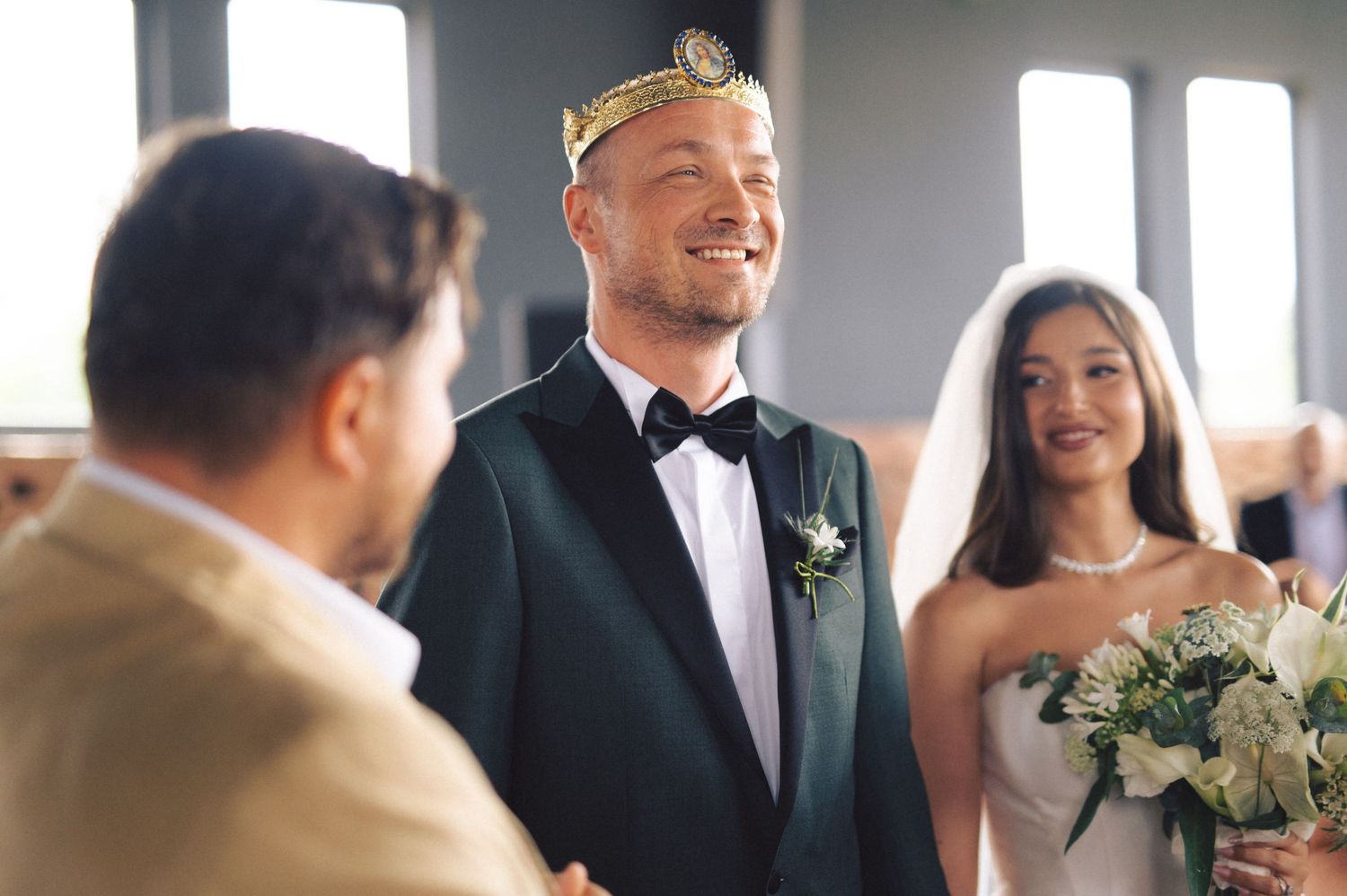 A joyful wedding ceremony captures a happy couple and their officiant sharing a light moment during the exchange of vows.