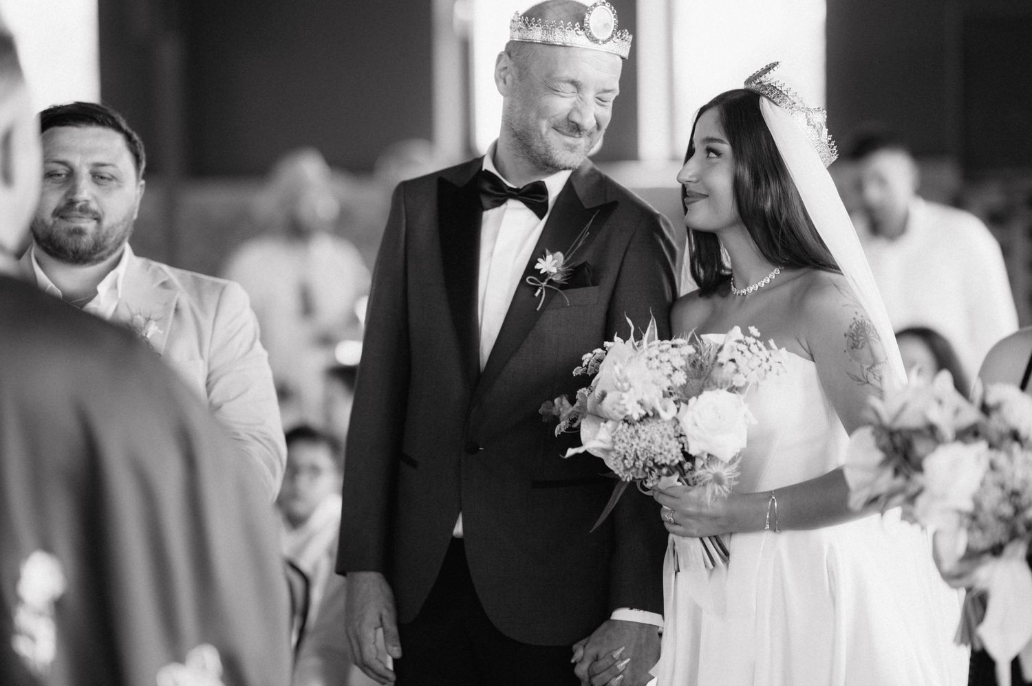 Black and white photograph of a wedding ceremony showing the bridal party walking down the aisle at church.