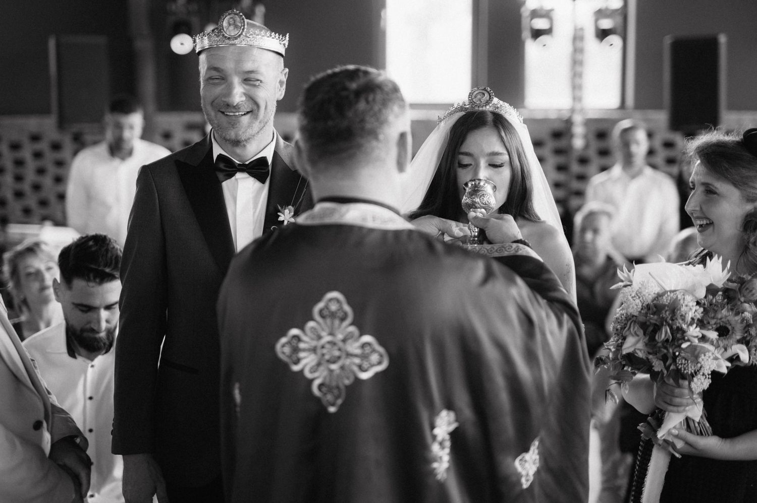 A black and white wedding photo shows a bride and groom at the altar during their wedding ceremony.