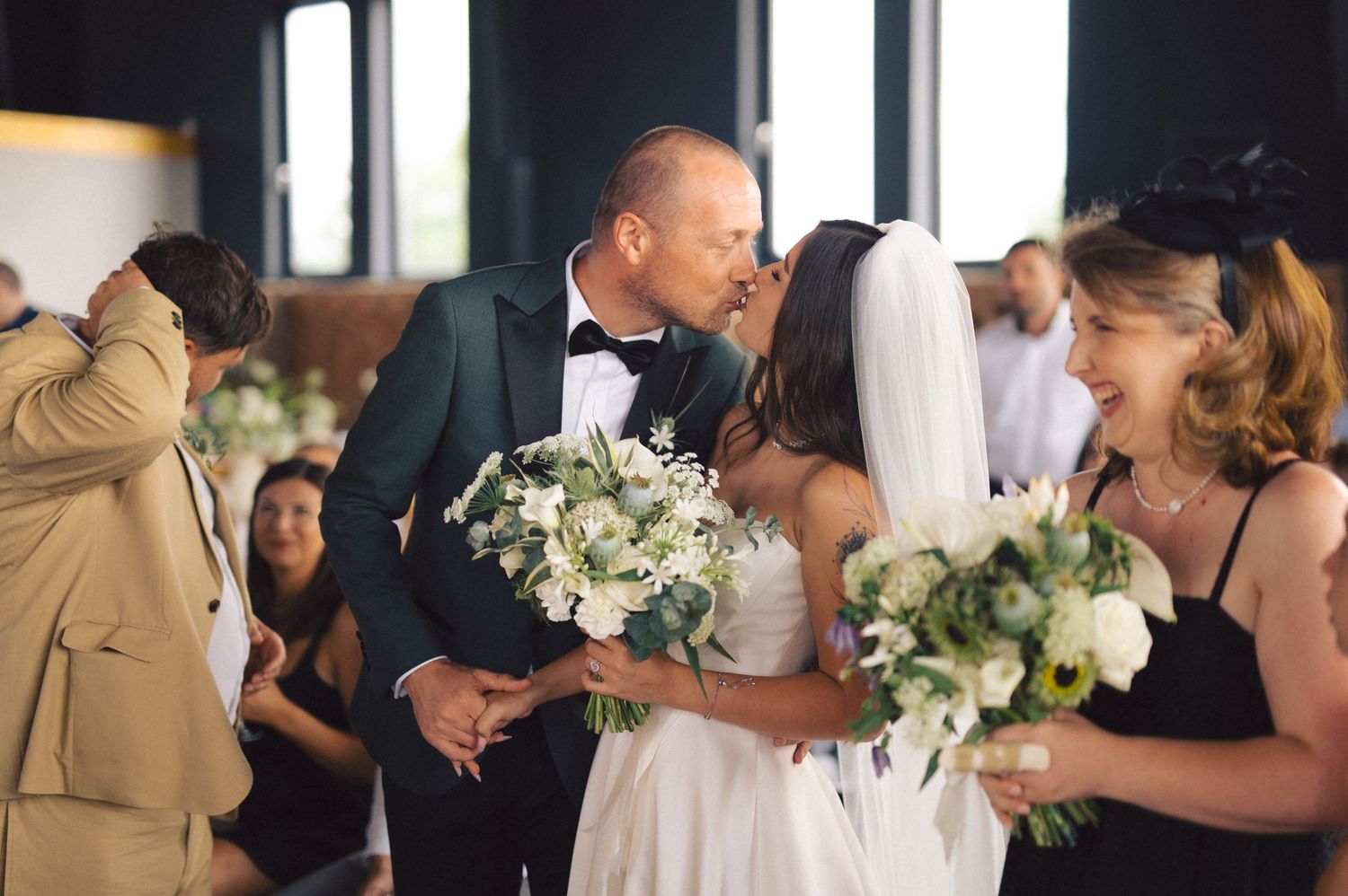 A joyful wedding celebration moment with white floral bouquets in an indoor venue.