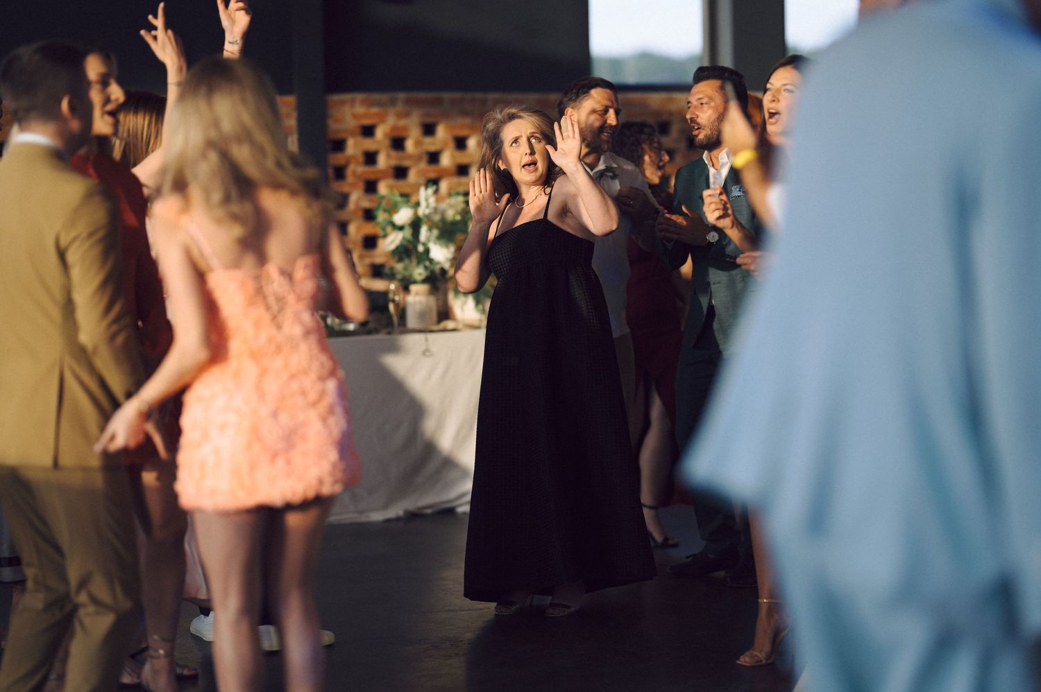People dancing and socializing at an evening party with some wearing formal attire.