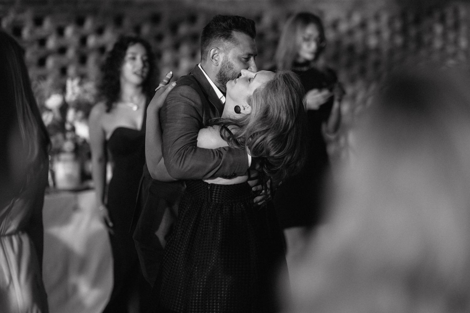 A black and white candid photograph of an intimate dance between a couple during a formal event.