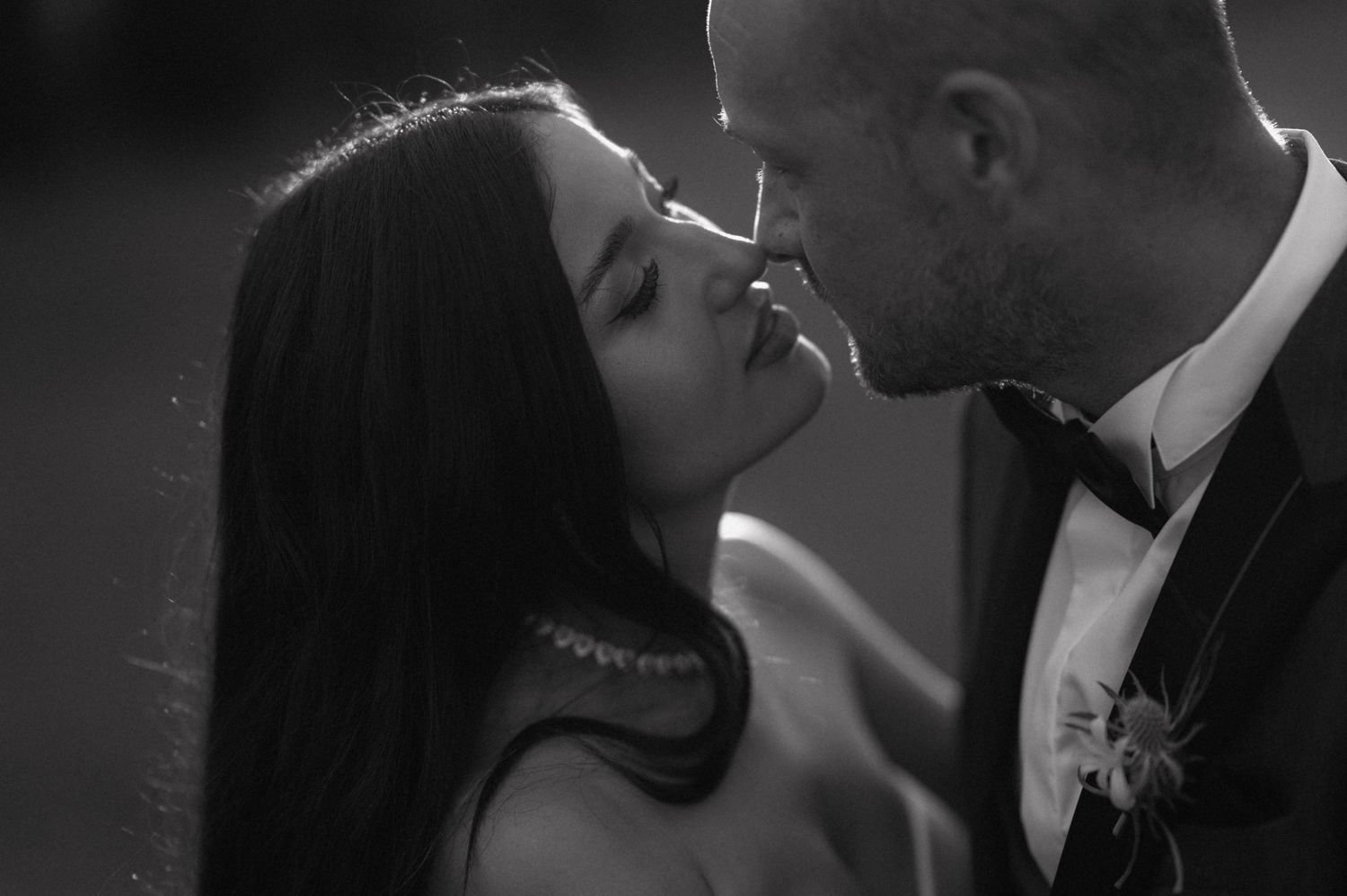 A romantic black and white photo sequence showing a couple in formal attire sharing intimate moments and kisses.