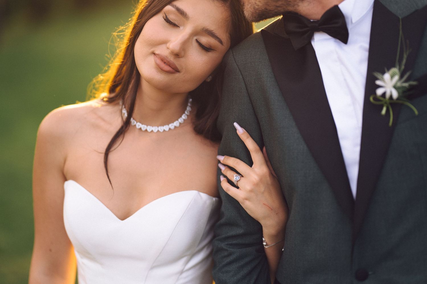 Elegant bride and groom pose romantically during outdoor wedding photo session.
