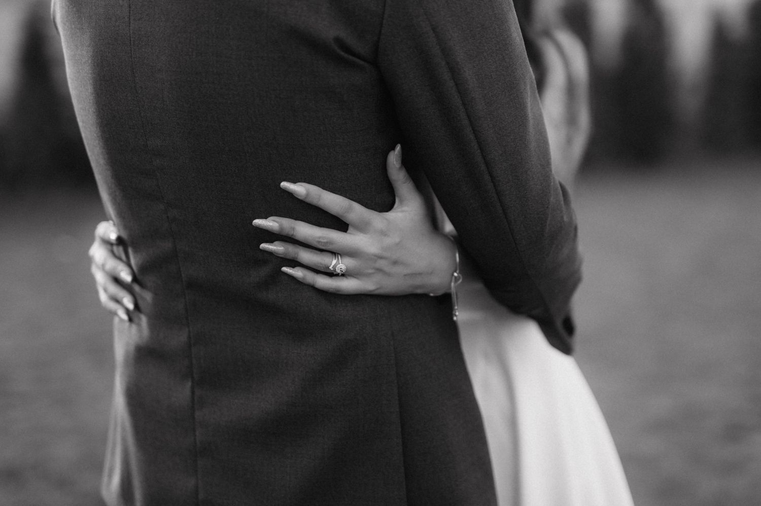 A black and white wedding image captures newlyweds embracing during an intimate dance moment.