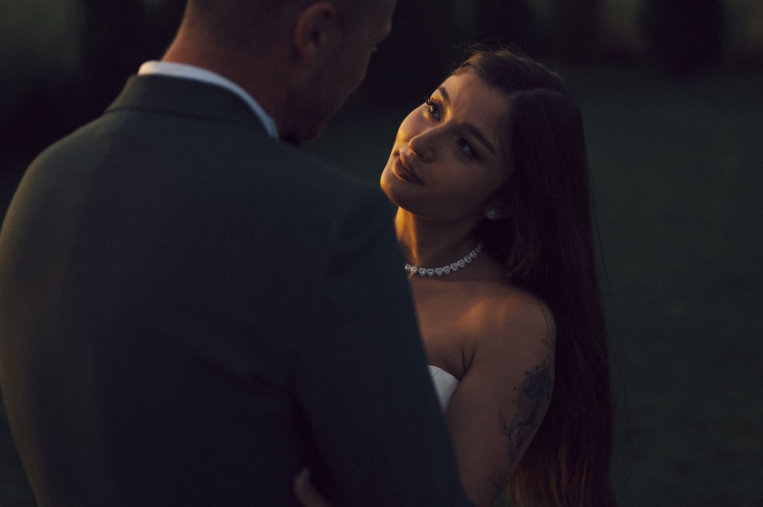 A romantic evening shot shows a soft-lit close-up of someone with long dark hair wearing an elegant pearl necklace.