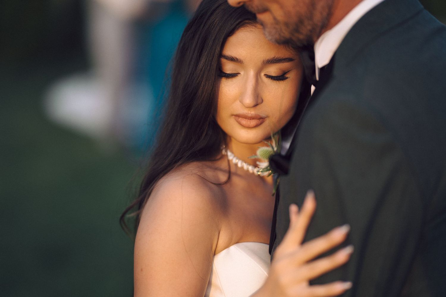 Romantic couple embraces in golden sunlight during outdoor wedding photography session.