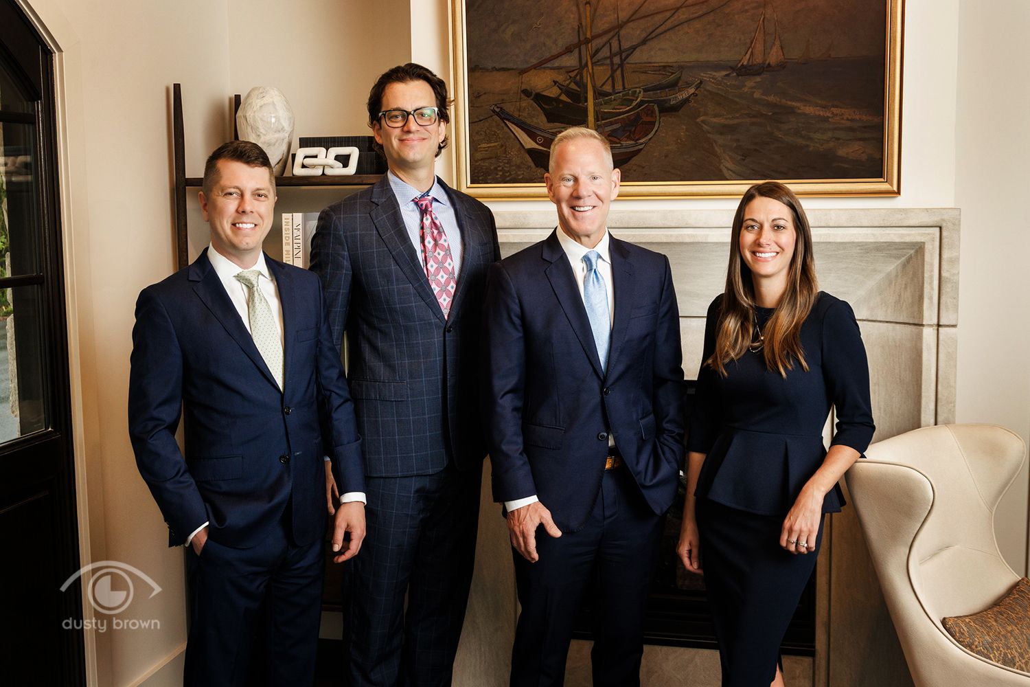 Professional business team stands together in formal attire in an office lobby.