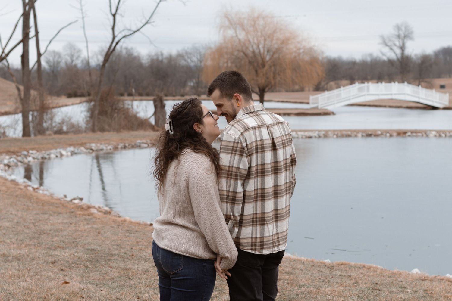 Couple sharing an intimate moment by a lake during their engagement photoshoot.