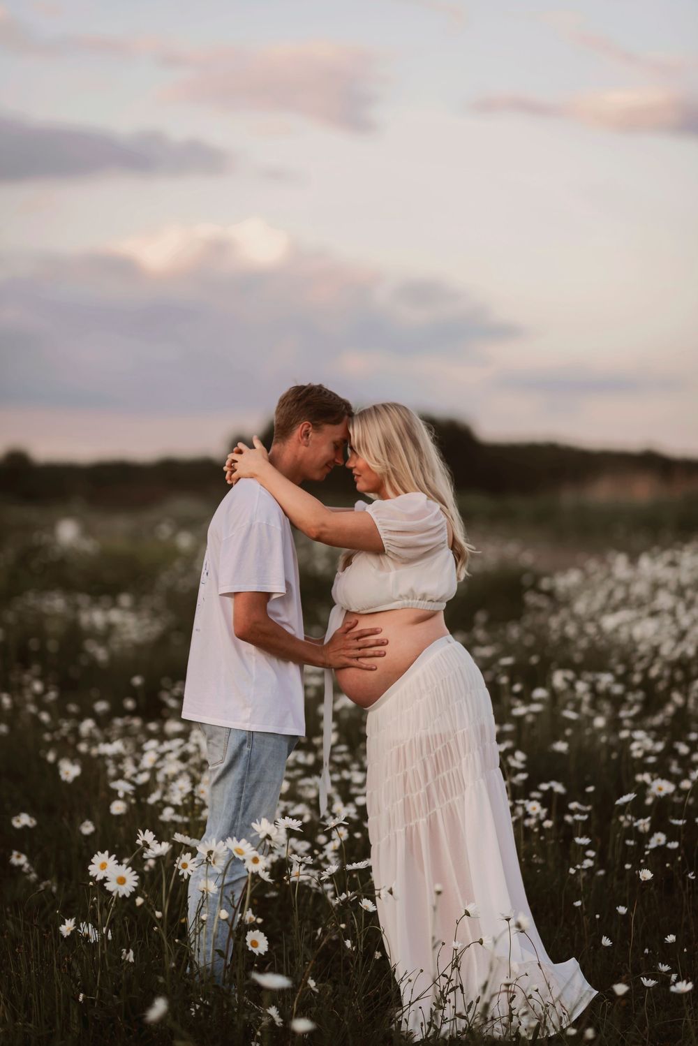 Two people share an intimate dance among blooming wildflowers in a summer meadow.