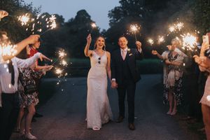 Wedding couple dances through sparkler arch at night during outdoor reception at Hall Farm - image captured by Grimsby photographers.