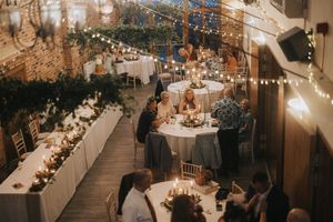 Cozy indoor wedding reception venue with string lights, round tables, and warm ambient lighting at Hall Farm.