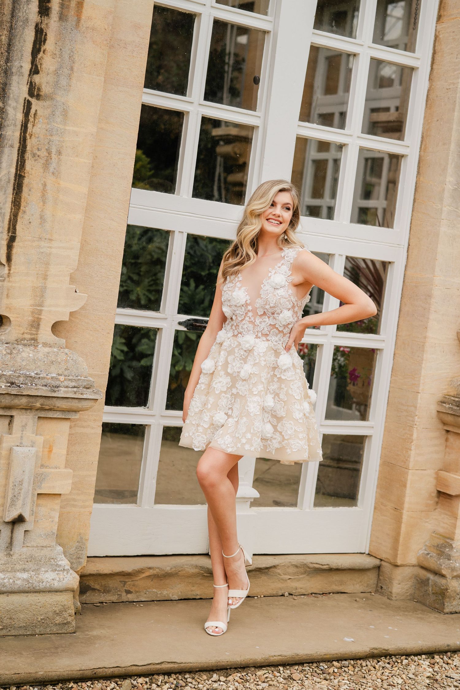 White lace dresses photographed against classic architectural columns and windows.