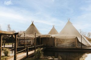 Three beige tipi-style canvas tents set up at an outdoor wedding venue at Nuddock Wood Lake. Taken by Grimsby photographers.