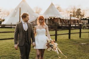 Wedding couple shares romantic moments in rustic outdoor setting with golden sunlight filtering through trees at Nuddock Wood Lake.