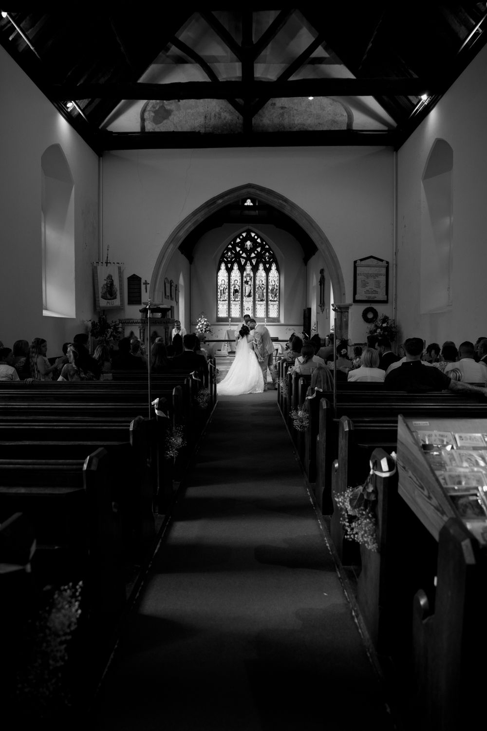 A black and white photo of a traditional church wedding ceremony with gothic architecture.