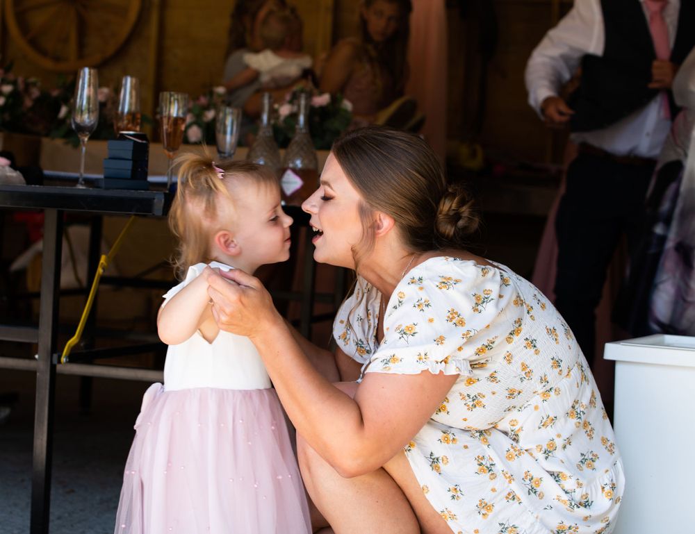 Sweet moment shared between parent and child at indoor wedding reception.