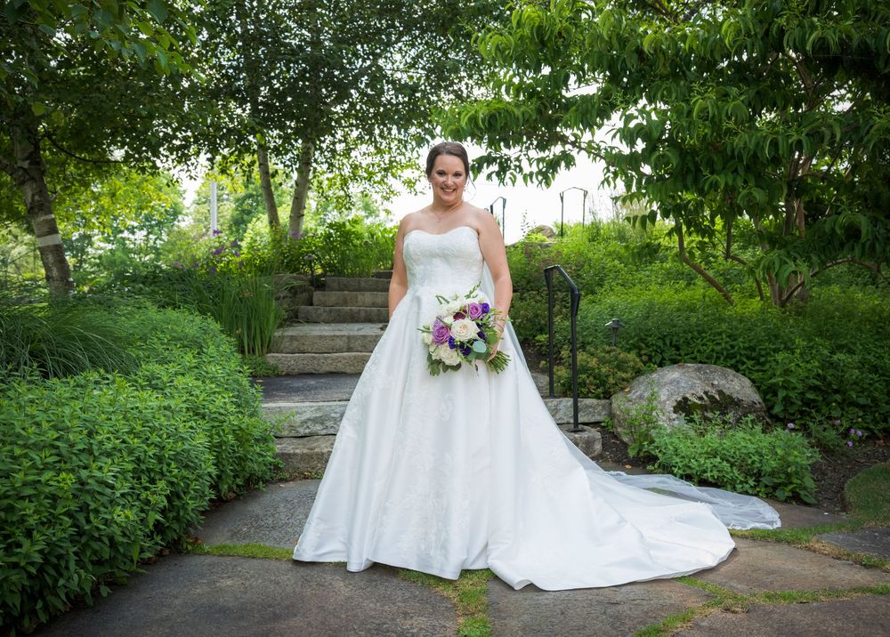 Scenic outdoor wedding photos captured in a lush garden setting with stone steps and natural greenery.