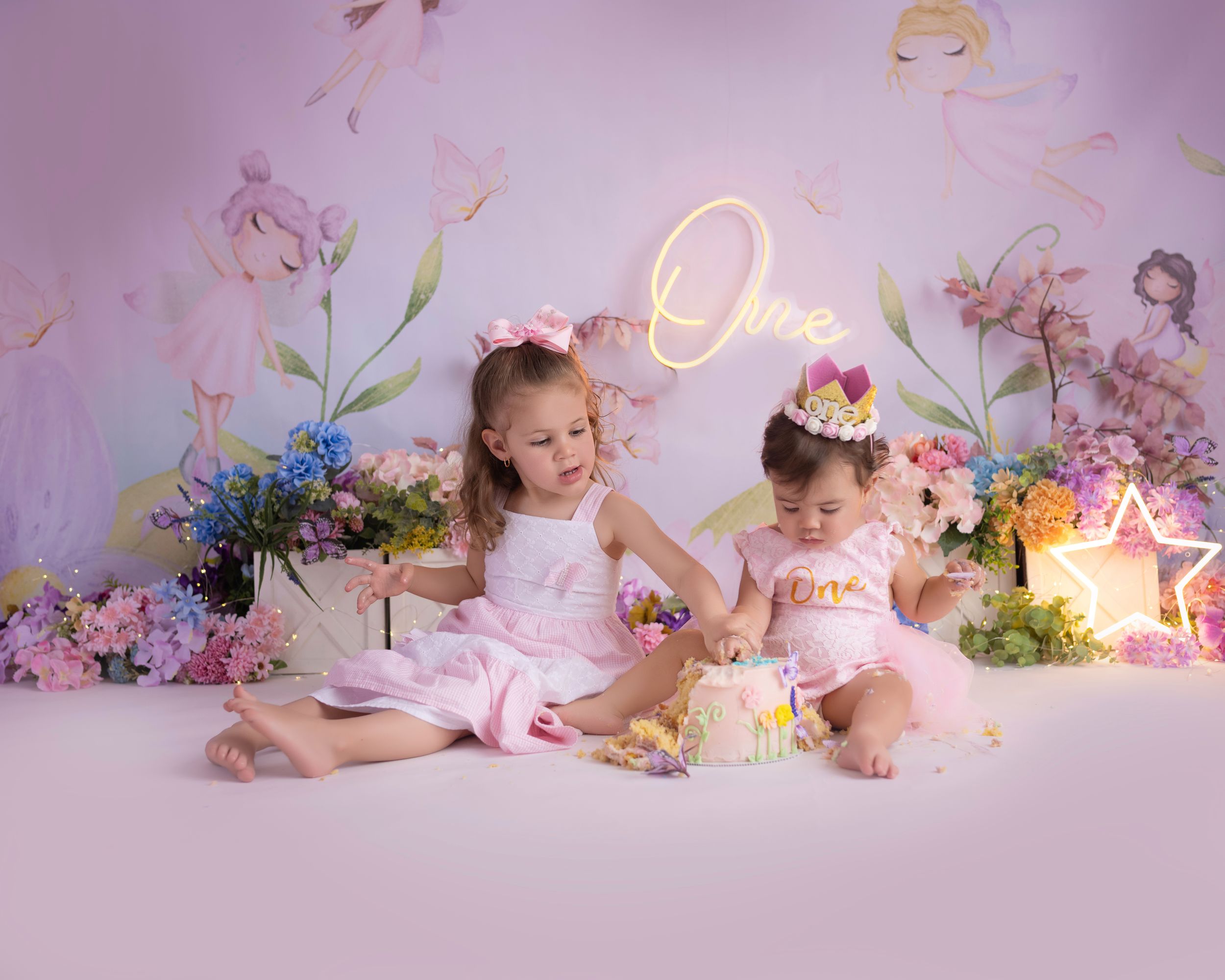 Birthday celebration scene with floral decorations and neon signage in pink tones.
