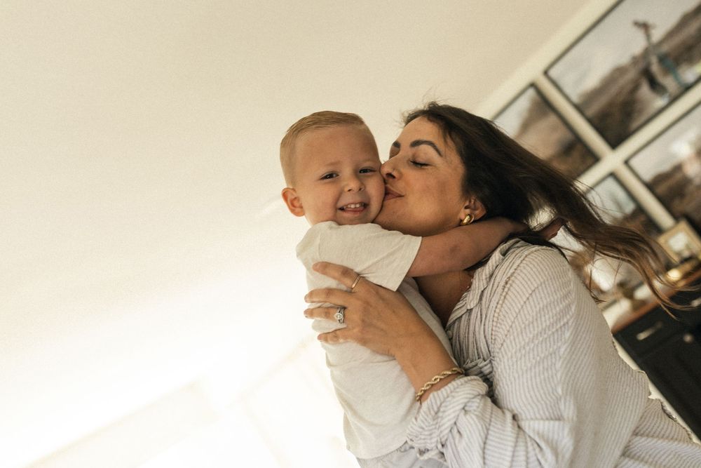 A candid family moment captured by the window showing tender affection and bonding.