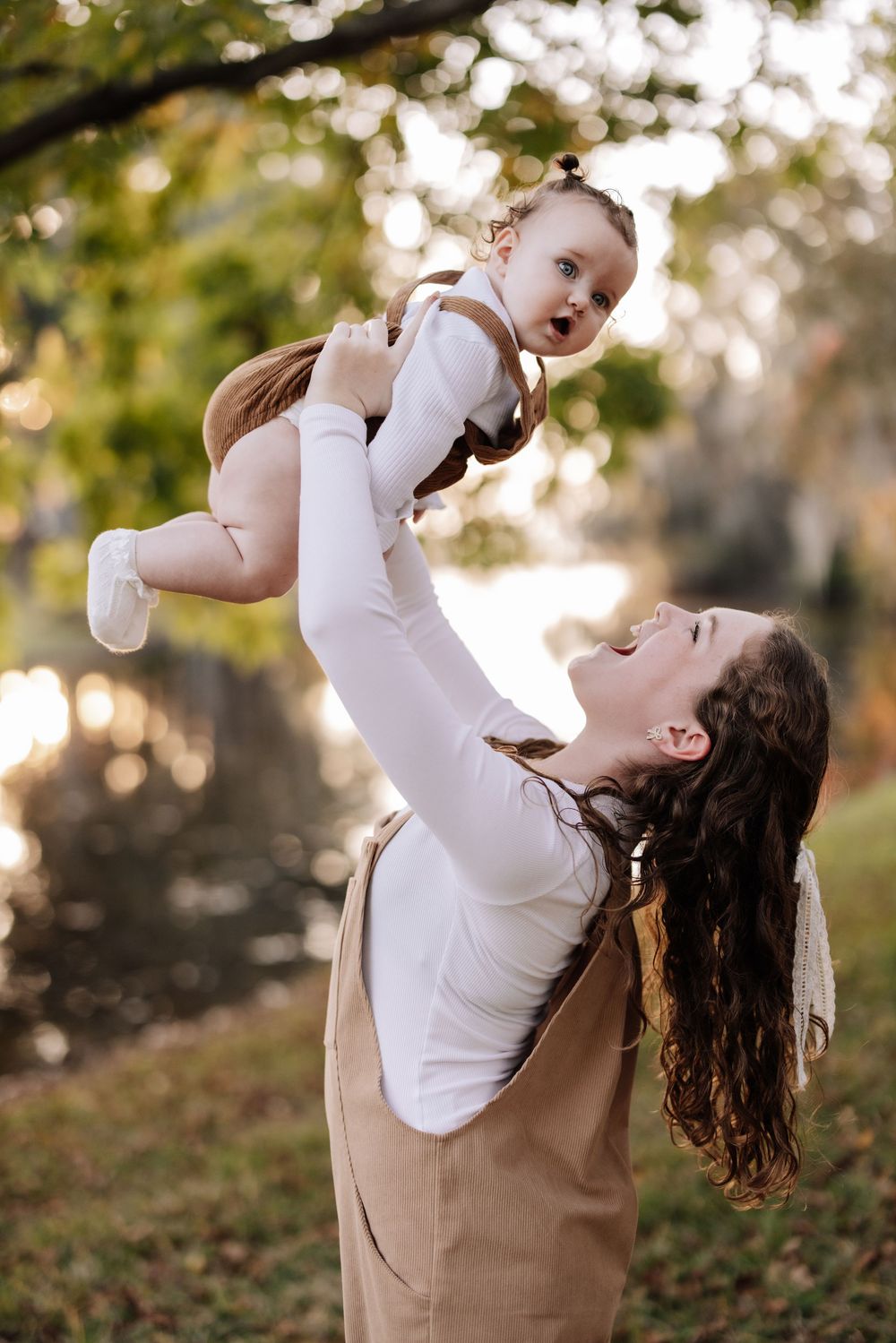 A parent in white and tan lifts and plays with a baby outdoors in a series of joyful candid moments at sunset.